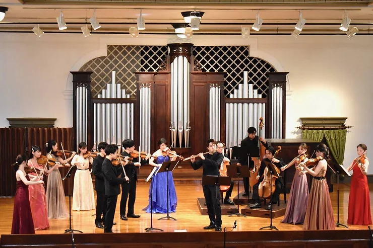ホールのステージで弦楽アンサンブルを演奏する奏者たち